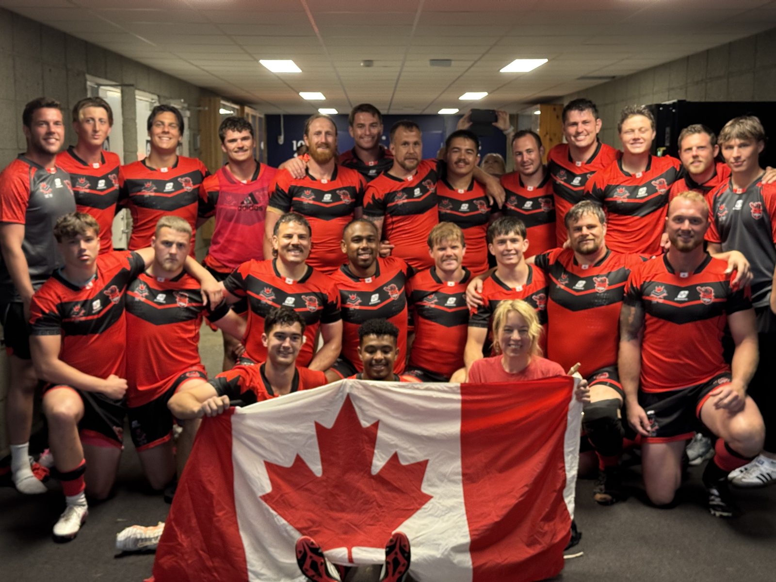 Canada Wolverines squad celebrating with the Canadian flag